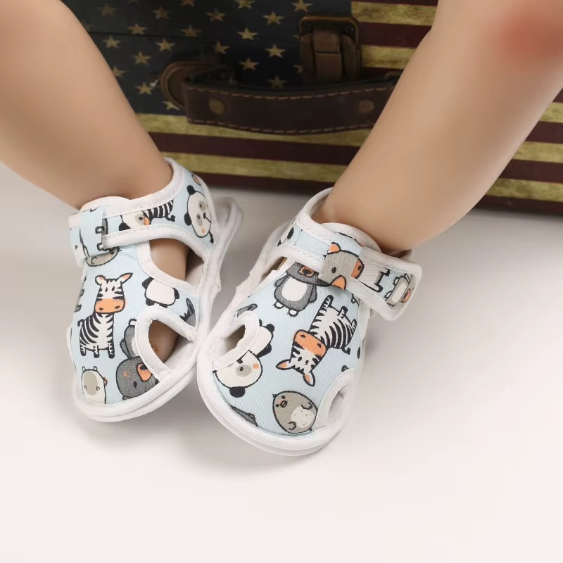 Light blue animal-print baby sandals shown on a seated display model