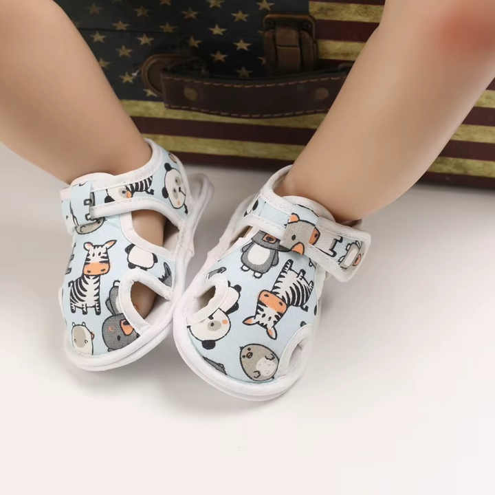 Light blue animal-print baby sandals shown on a seated display model