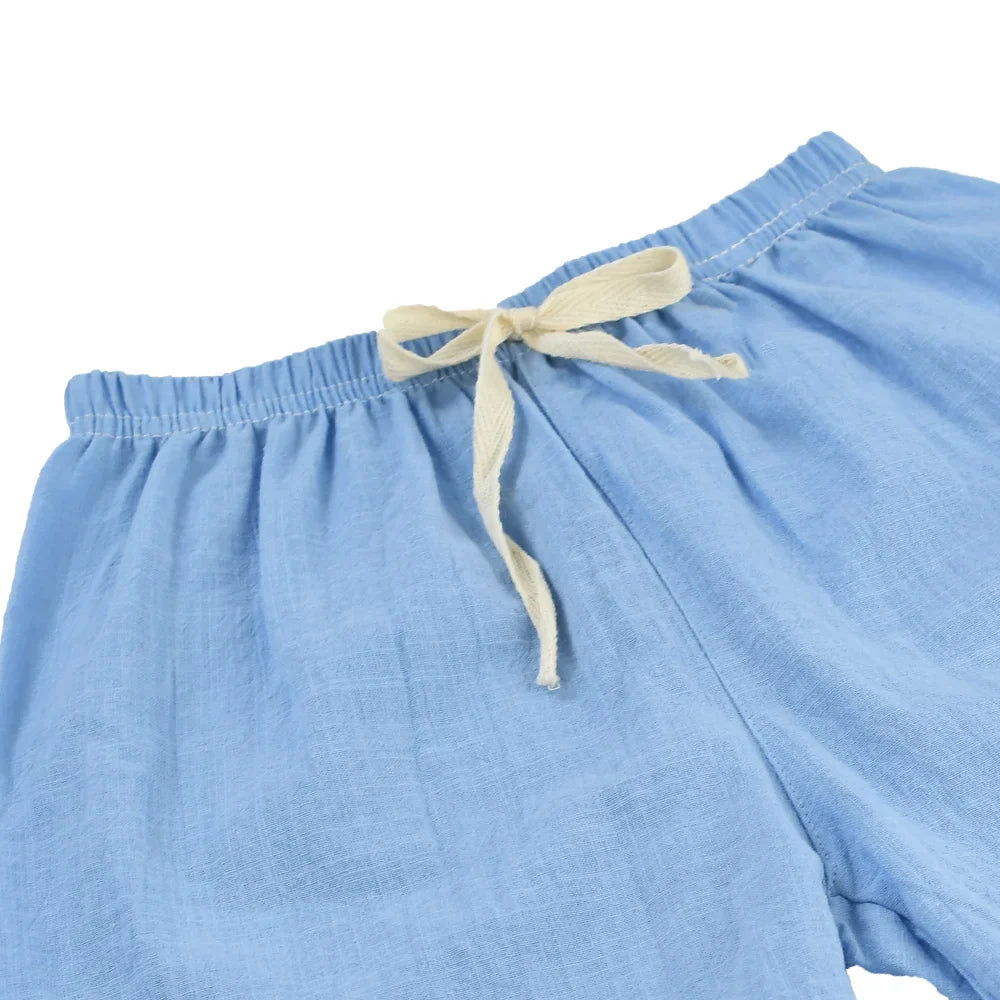 Light blue kids' shorts showing the elastic waistband and cream-colored drawstring