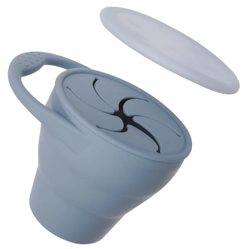 Light blue silicone snack cup with its cover lifted above the flexible opening