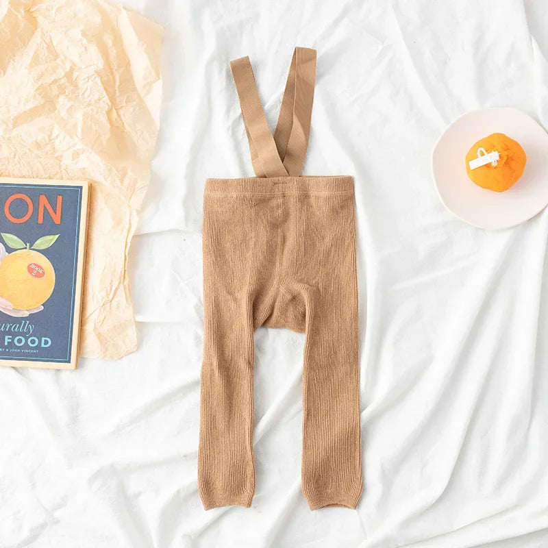 Light brown ribbed baby leggings with matching suspenders laid flat