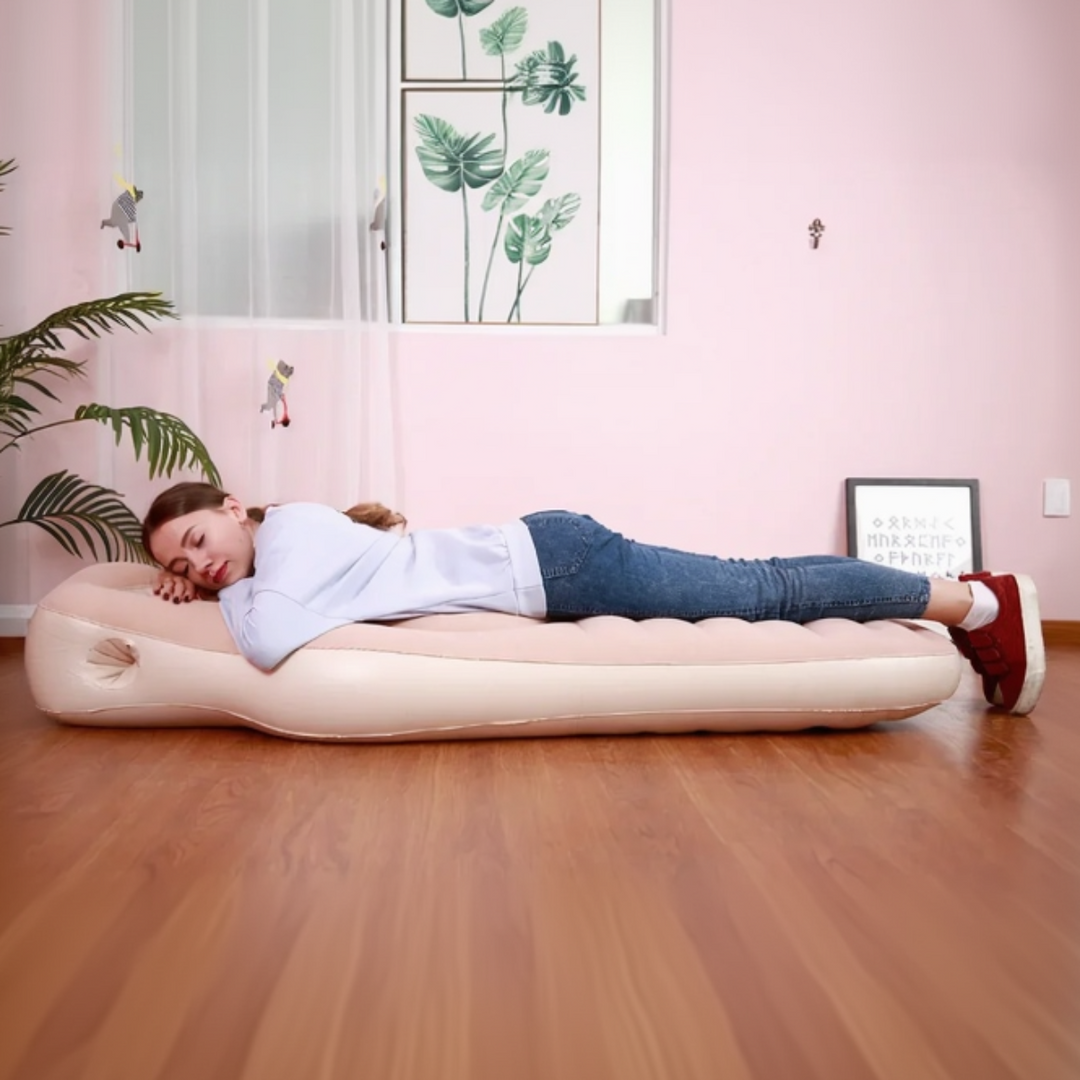 Woman resting lengthwise on a light-colored inflatable pregnancy pillow