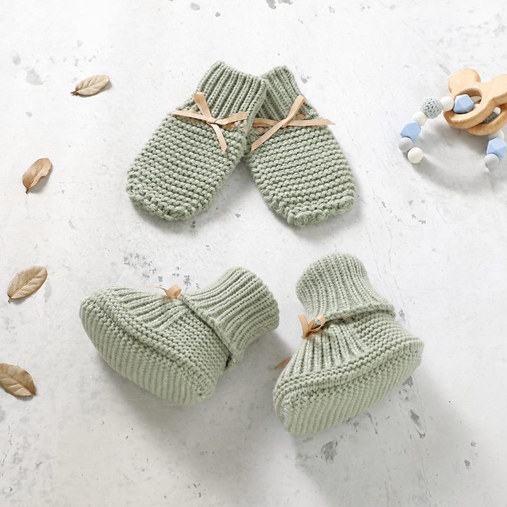 Light green knitted baby booties and matching mittens