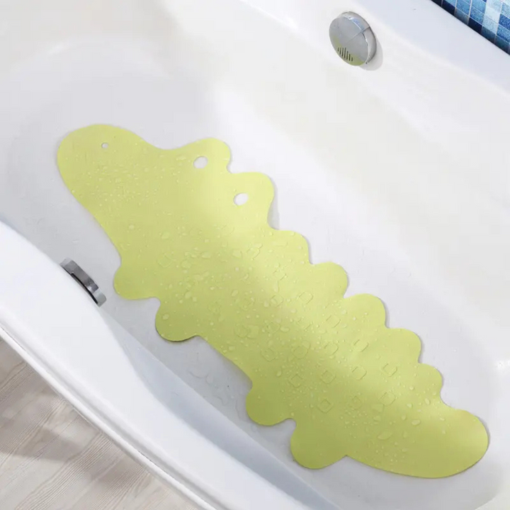 Light green crocodile bath mat inside a white bathtub