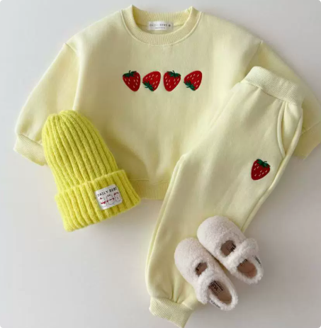 Light yellow strawberry sweater and matching pants displayed with a yellow knit hat and slippers
