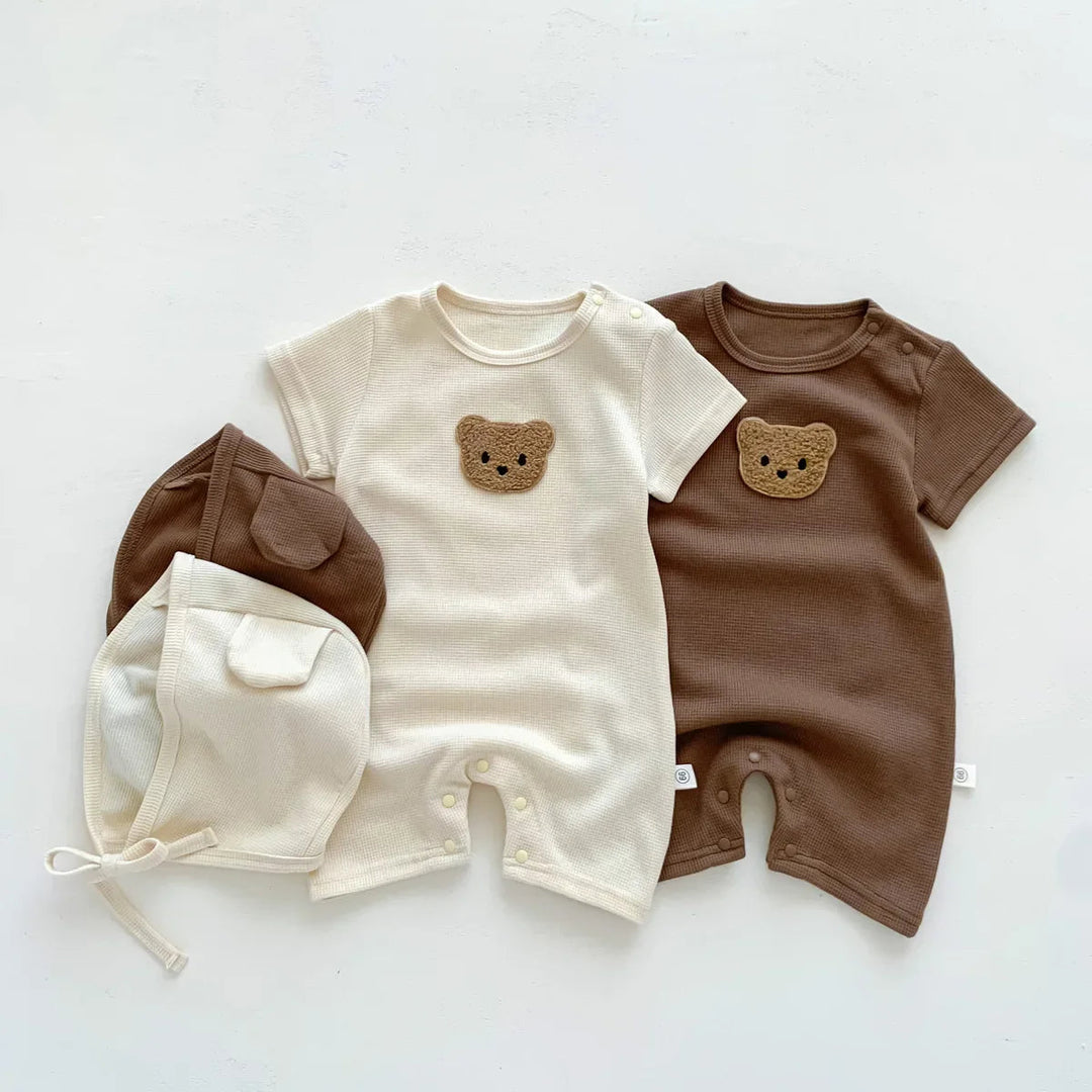 Beige and brown short-sleeve baby rompers with bear chest details and matching hats