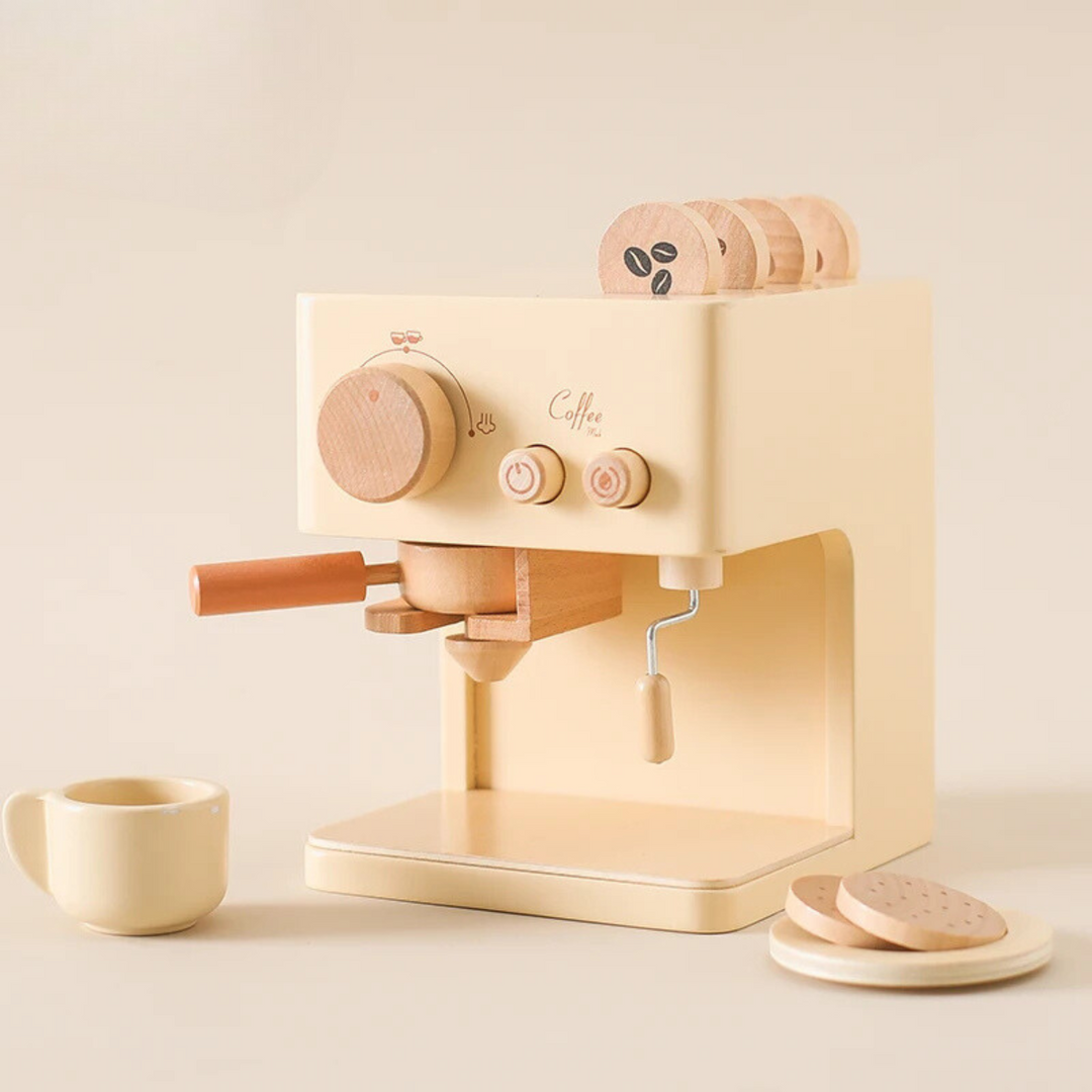 Beige wooden espresso machine with a coffee handle, cup, saucer, pretend cookies, and coffee discs.