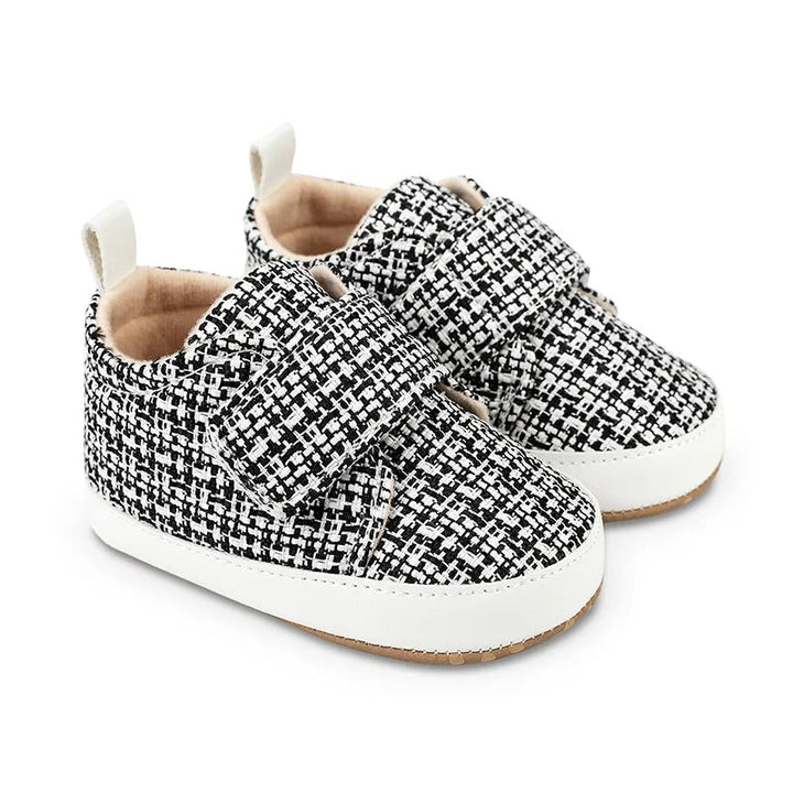 Black-and-white baby shoes with textured uppers and wide hook-and-loop straps