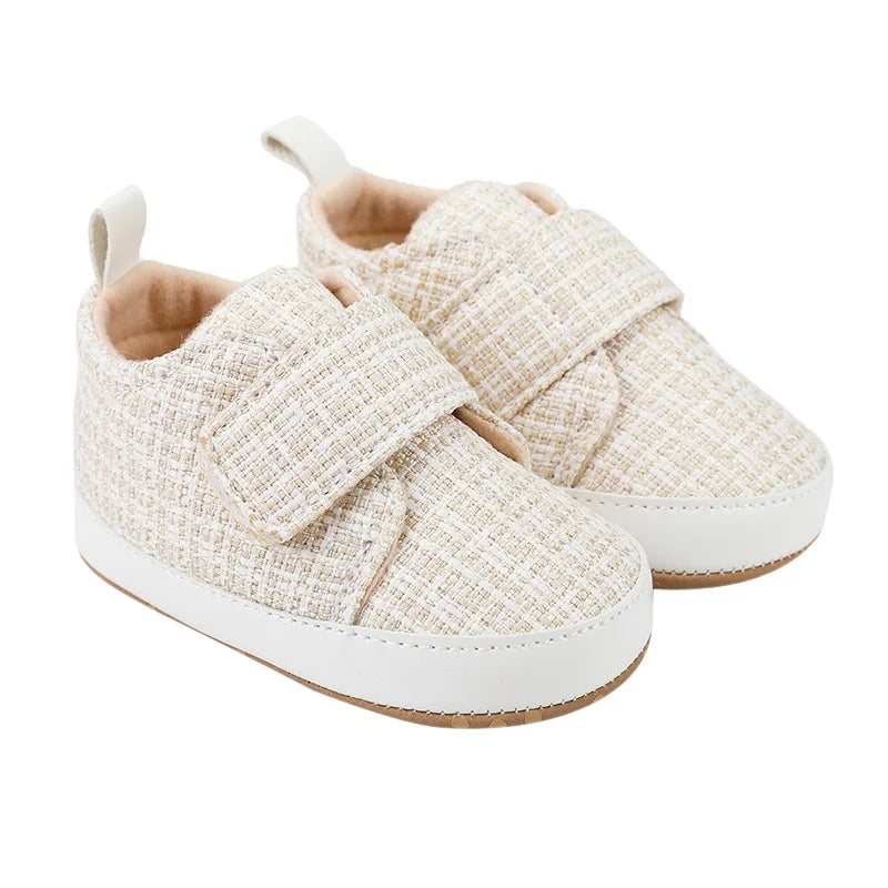 White baby shoes with textured uppers, wide hook-and-loop straps, and contrast soles