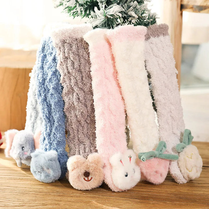 Long fluffy baby socks with animal and fruit details arranged upright in assorted colors.