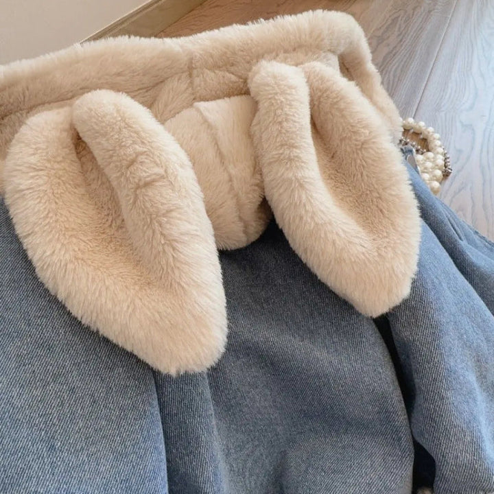 Close-up of long cream bunny ears hanging from the denim jacket&