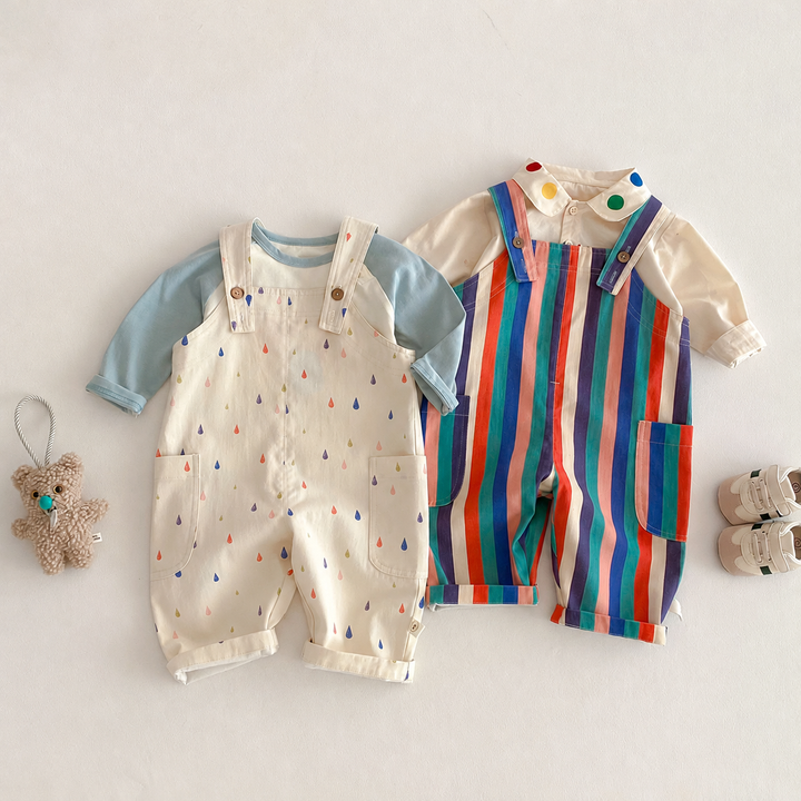 Cream raindrop and striped long overalls layered over light blue and cream long-sleeve tops
