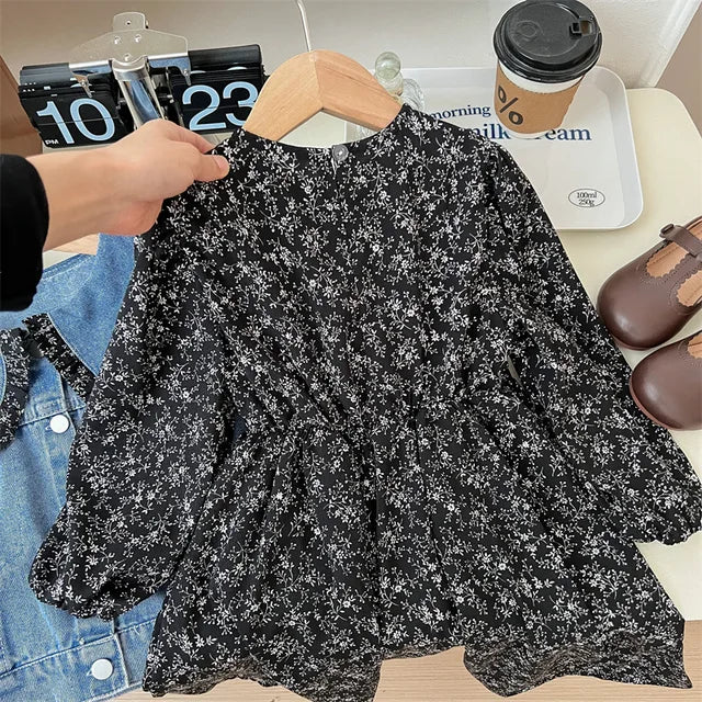 Front view of the black floral dress with long sleeves and a gathered waist