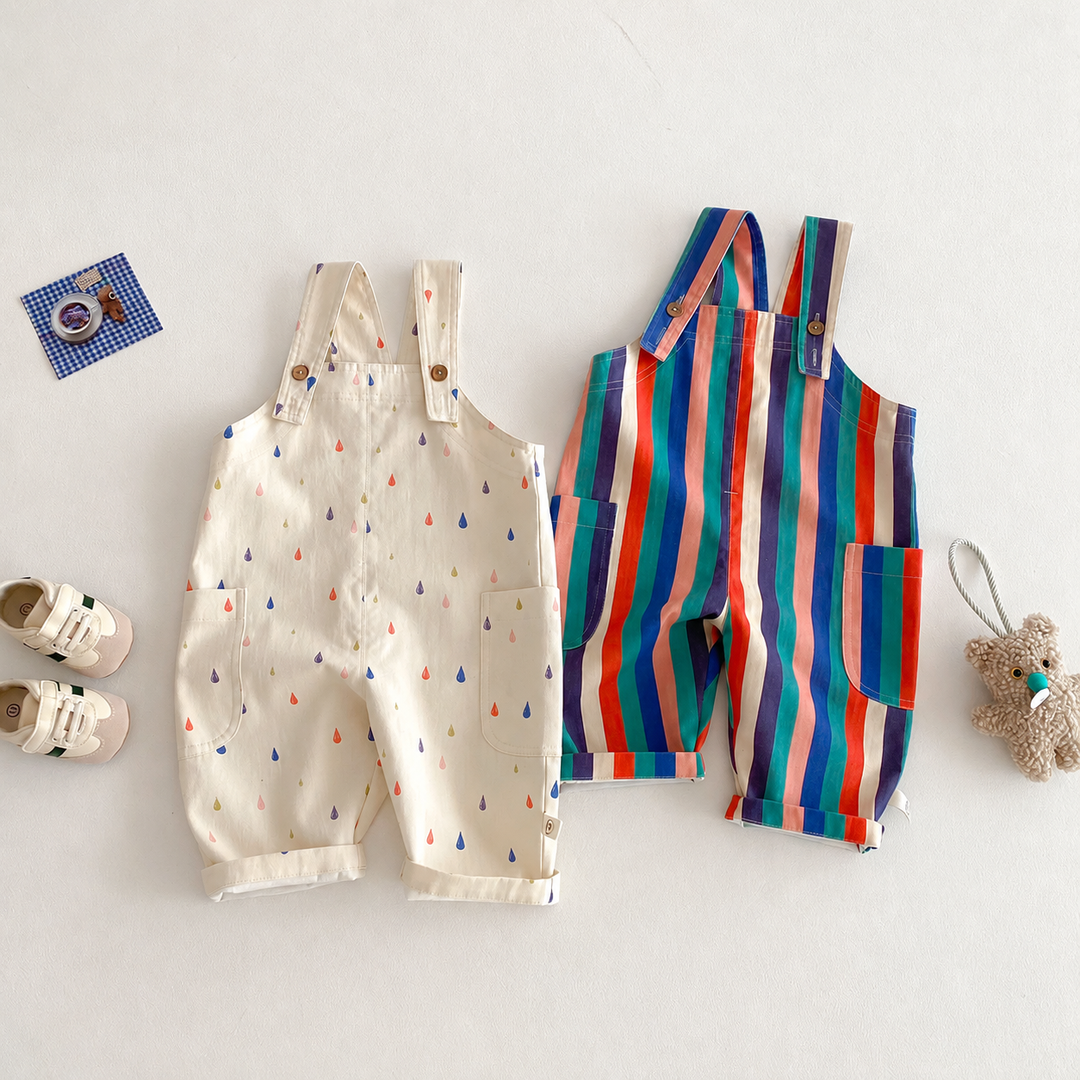 Cream raindrop and multicolored striped long overalls laid flat with buttoned shoulder straps