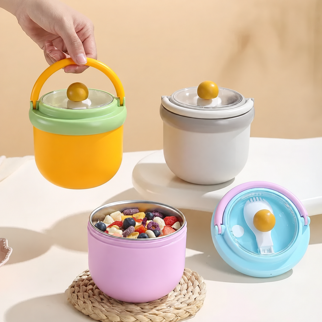 Yellow lunch bowl lifted by its handle beside gray and open pink bowls.