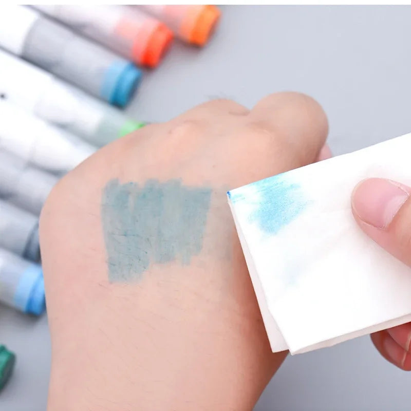 Blue ink on a hand being wiped with a white pad