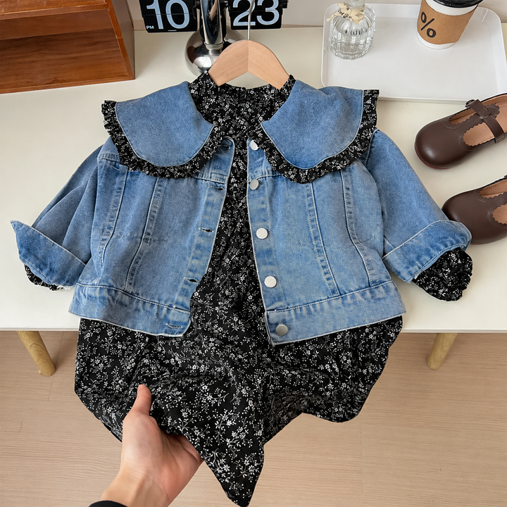 Blue denim jacket layered over a black floral dress, with a wide, ruffle-trimmed collar