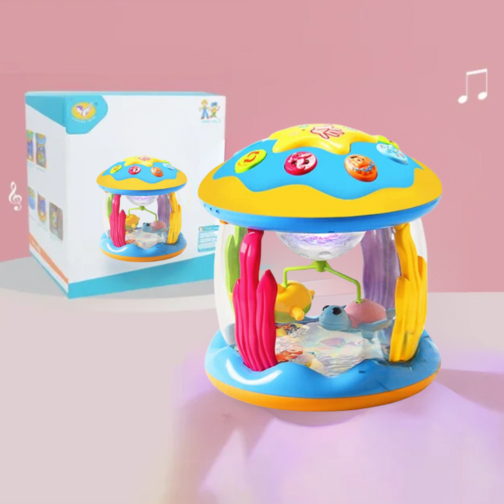 Colorful musical carousel toy with top buttons beside its retail box