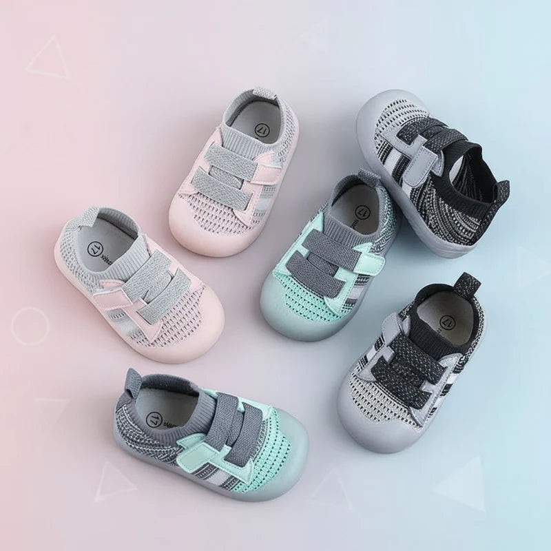 Pink, green, and black-gray mesh baby shoes with strap closures arranged on a pastel background