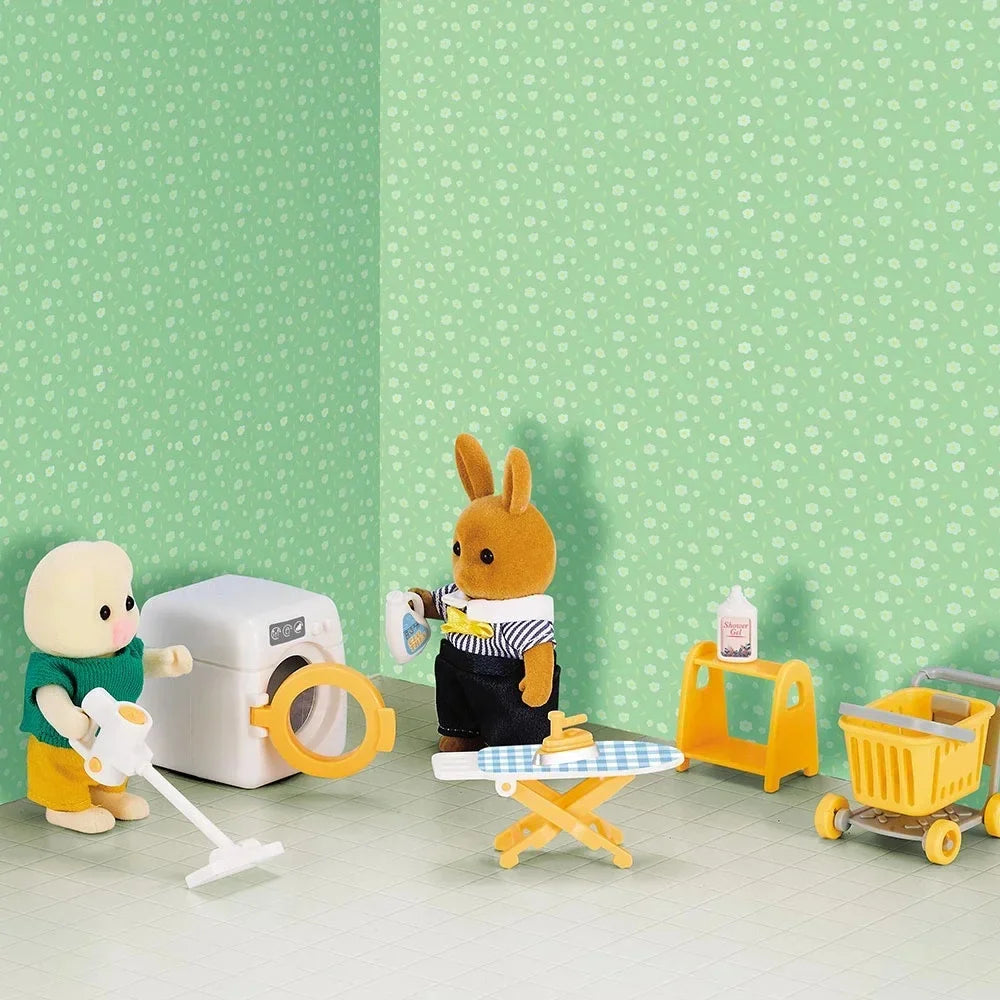 Miniature washer, ironing board, rack, cart, and vacuum in a green room scene with animal figures