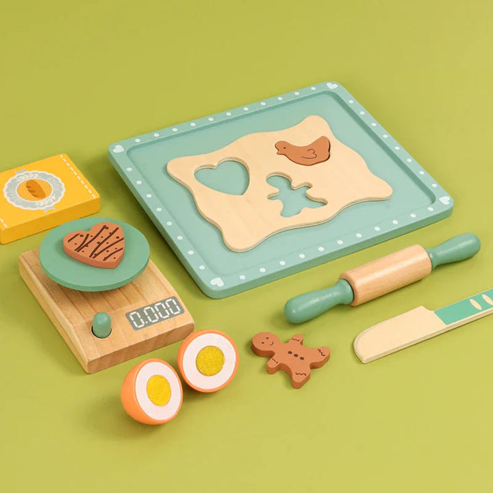 Mint-green baking tray and dough board beside a play scale, rolling pin, knife and pretend ingredients