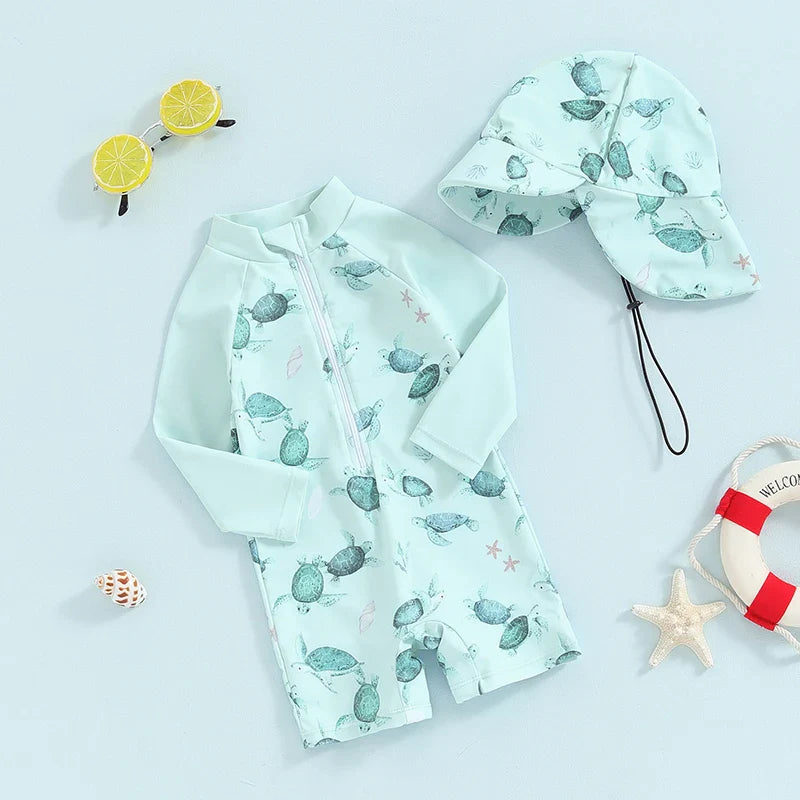 Mint green sea turtle-print one-piece swimsuit and matching hat with an extended neck flap.