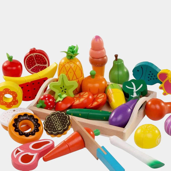 Assorted wooden play food, including fruit, vegetables, fish, sweets, and toy knives
