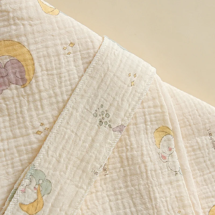 Textured cotton swaddle blanket with pastel moon and elephant patterns
