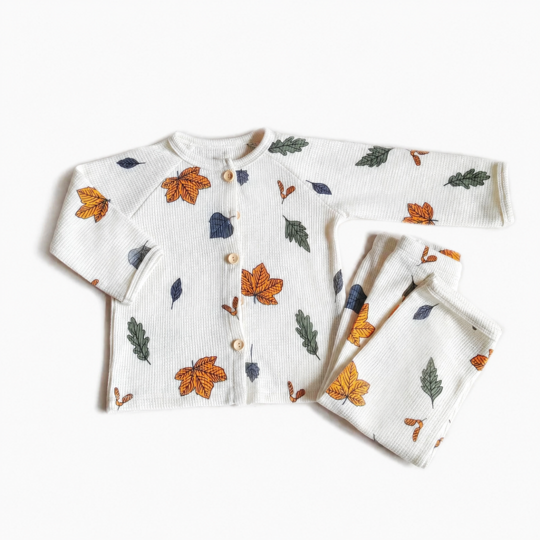 White long-sleeve pajama set with multicolored autumn leaves and a button-front top