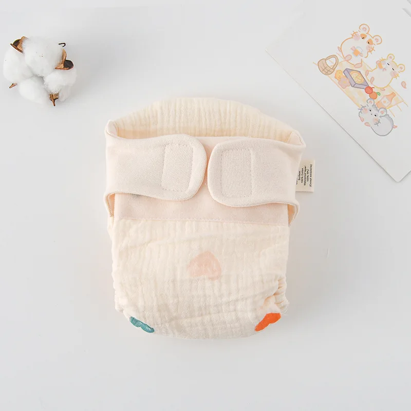 Cloth diaper with scattered multicolored heart prints and cream fastening tabs