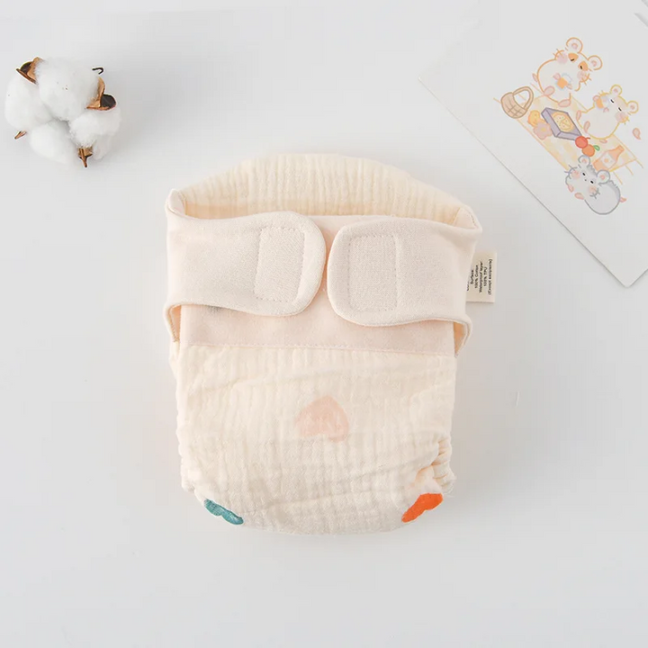 Cloth diaper with scattered multicolored heart prints and cream fastening tabs