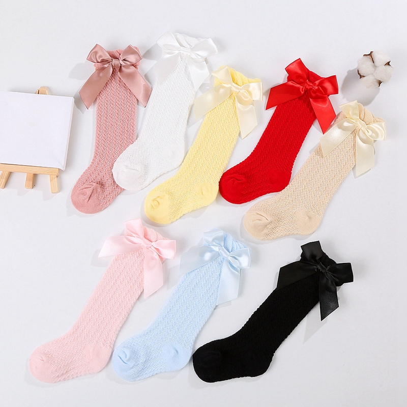 Color assortment of knee-high bow socks arranged on a white background