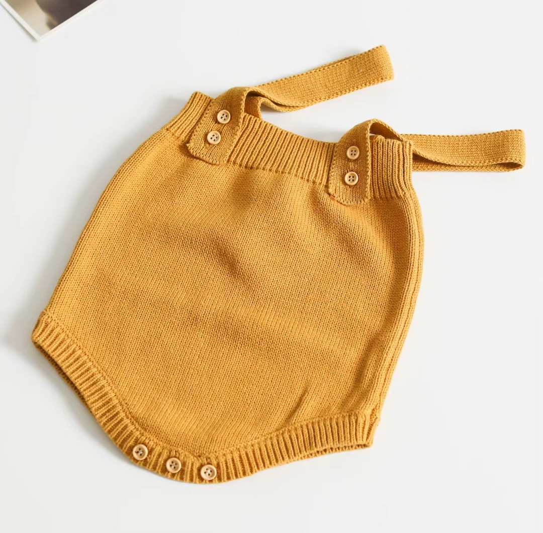 Mustard yellow knit baby romper with shoulder straps and buttoned crotch opening