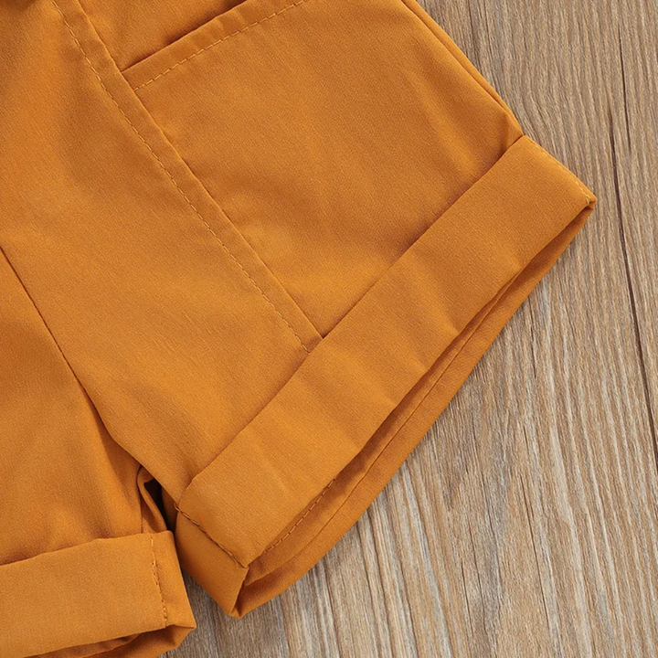 Close-up of the folded cuff and stitching on the mustard shorts.
