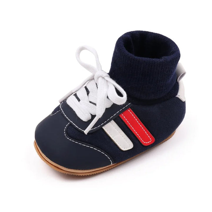 Navy baby shoe with a ribbed cuff, white laces, and contrasting side accents