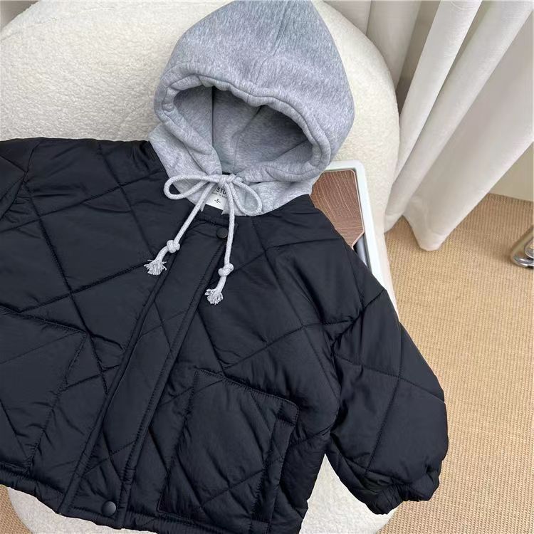 Navy blue diamond-quilted jacket with a gray hood laid on a chair.