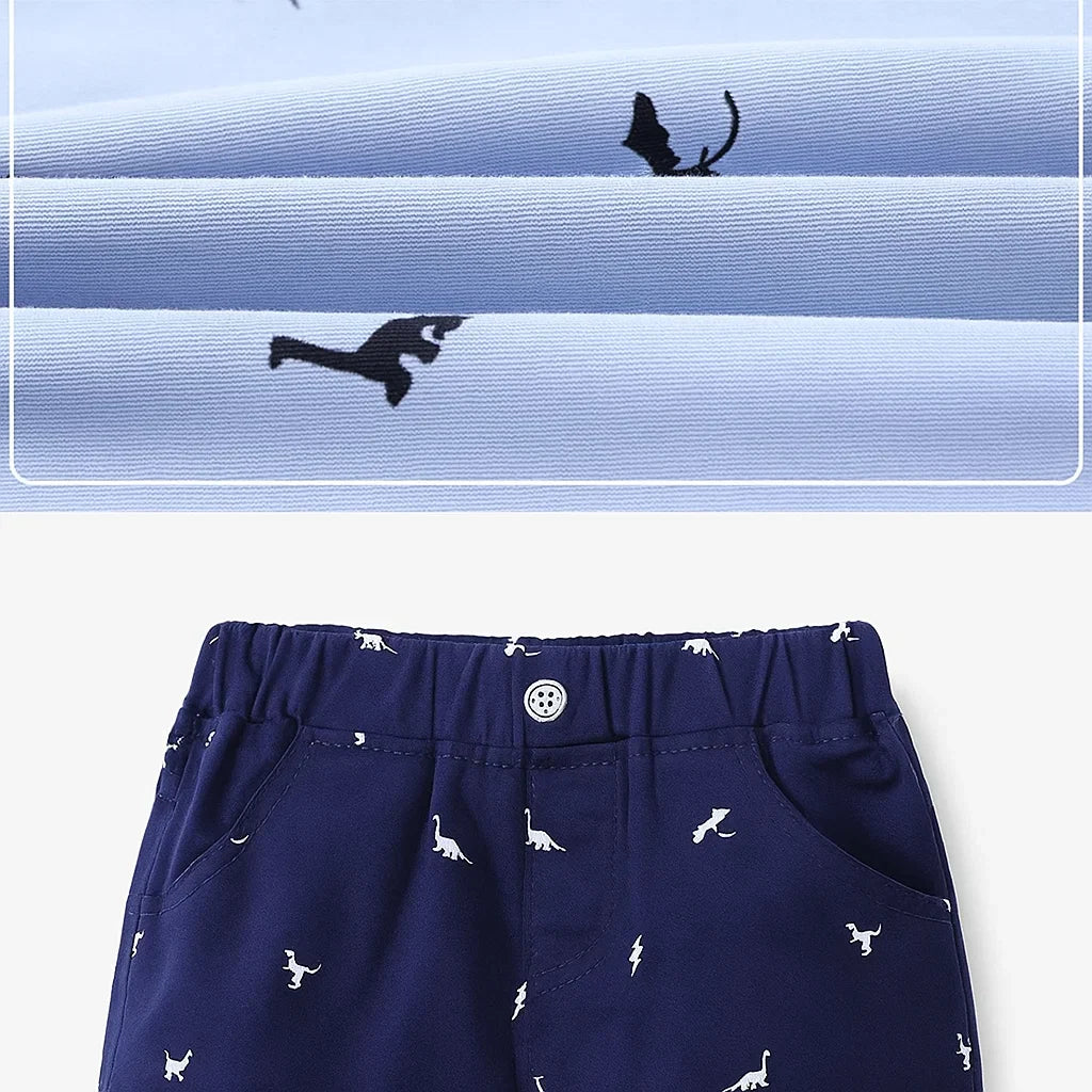 Close-up of dinosaur-print fabric above navy shorts with an elastic waistband