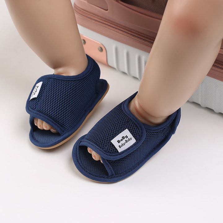 Navy mesh baby sandals shown on small feet with the adjustable straps fastened