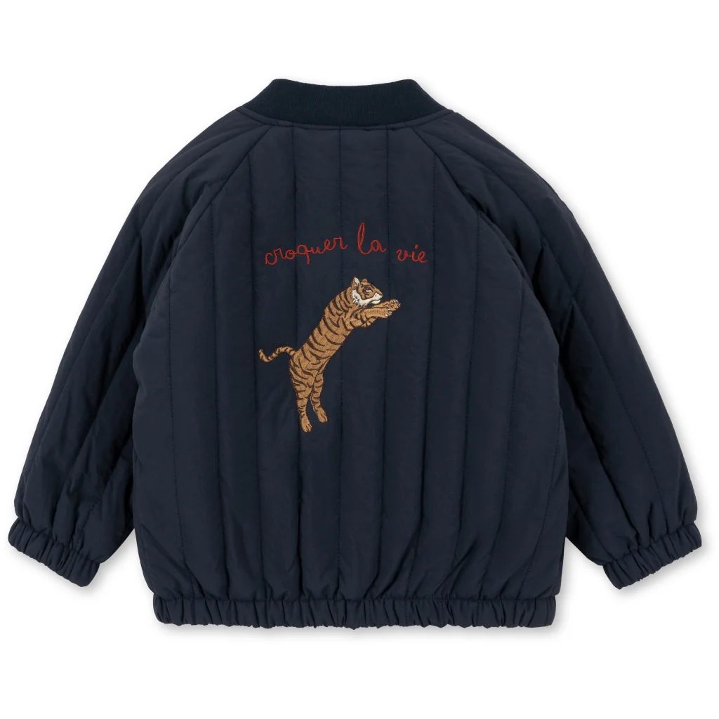 Rear view of the blue quilted jacket with tiger embroidery, ribbed collar and gathered hem