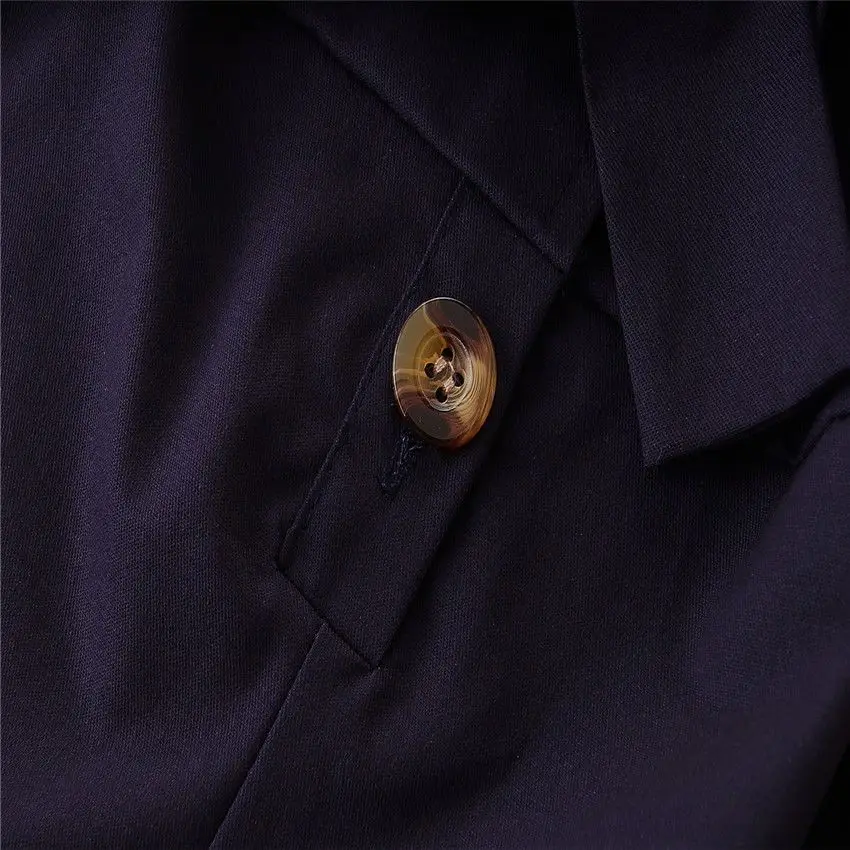Button and placket detail on the navy bow-waist romper