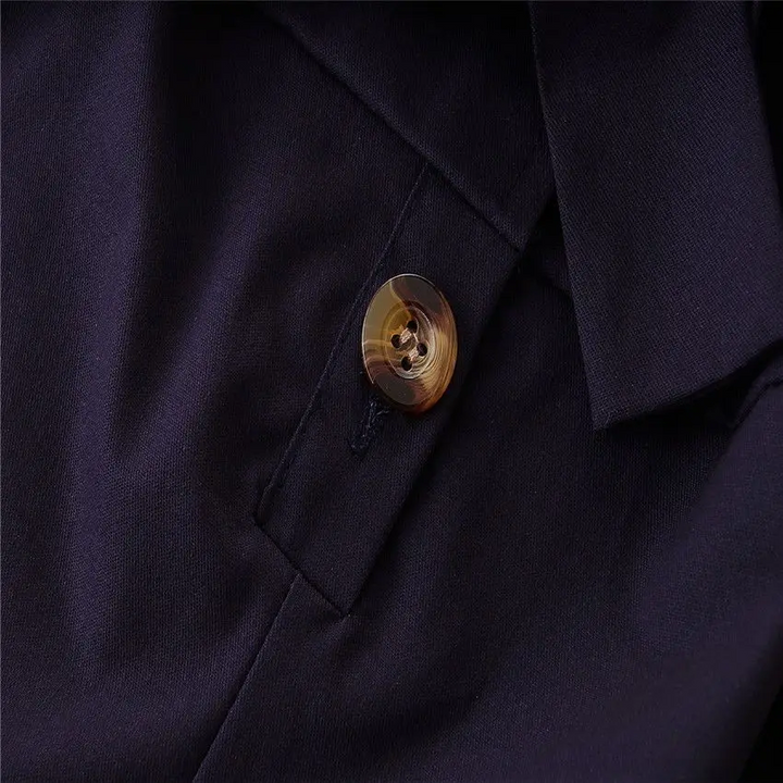 Button and placket detail on the navy bow-waist romper