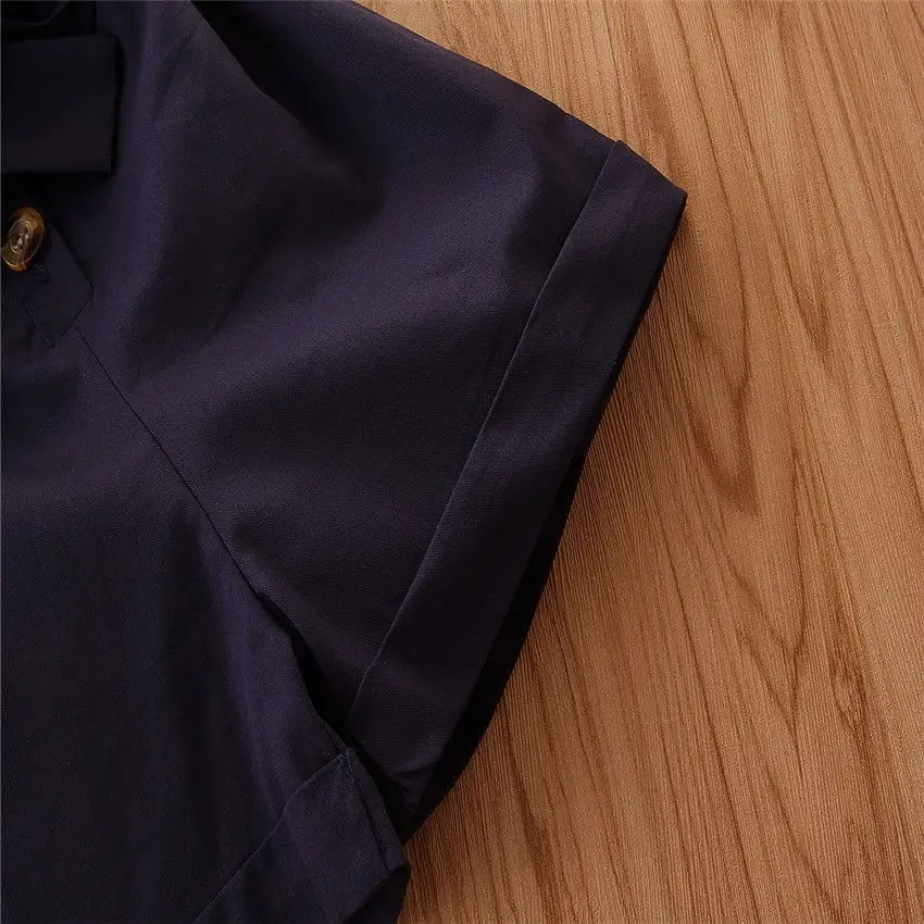 Folded sleeve cuff and seam detail on the navy romper