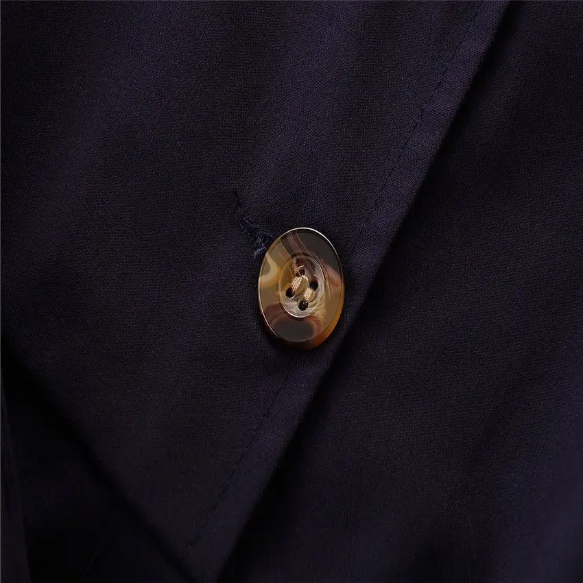 Close-up of a marbled brown button on the navy romper