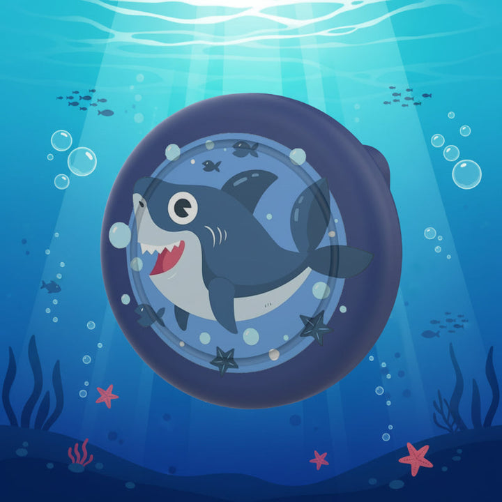 Dark blue AirTag brooch case with a smiling shark design