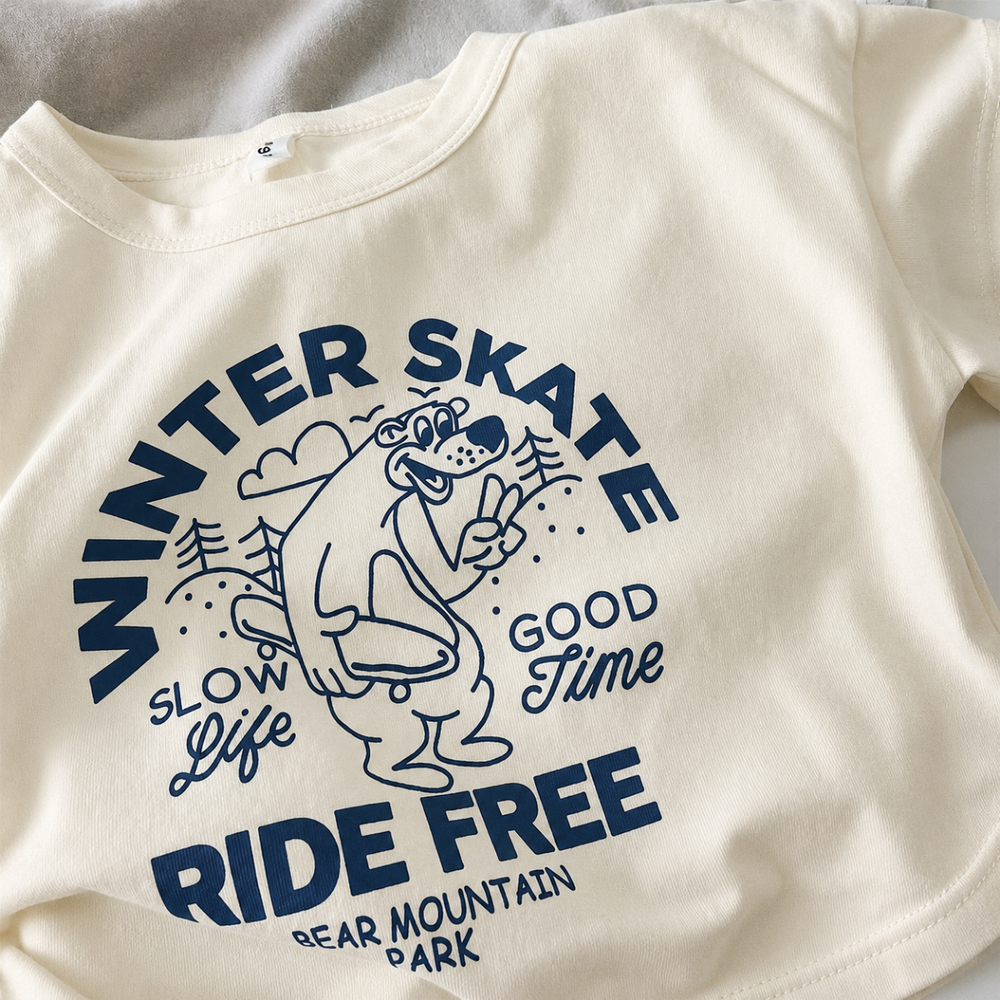 Close-up of the navy winter skate bear graphic on a cream cotton-blend T-shirt