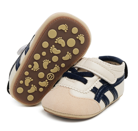 Cream baby sneakers with navy stripes, showing round and footprint-shaped sole details