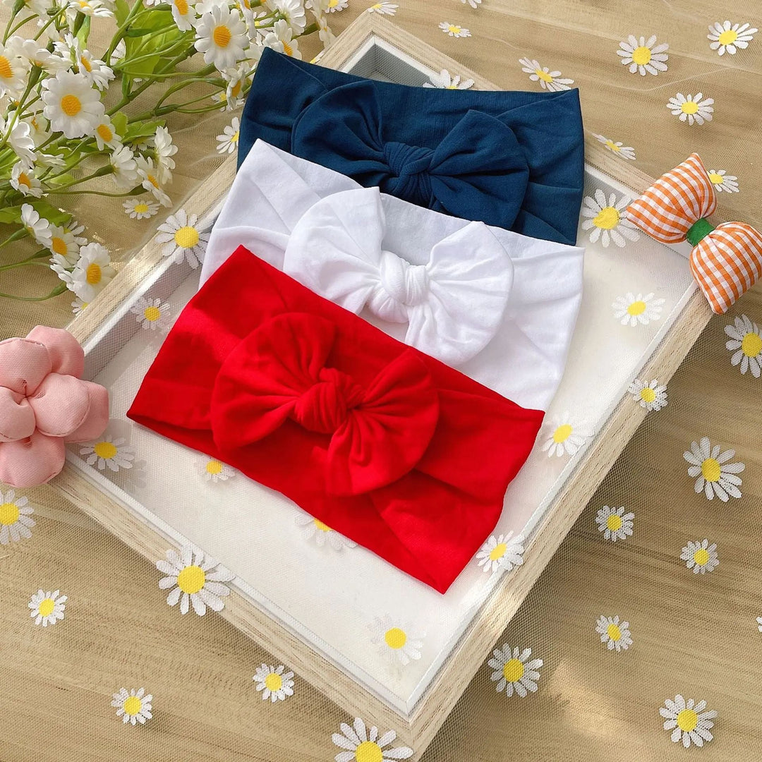 Navy, white, and red bow headbands arranged in a frame