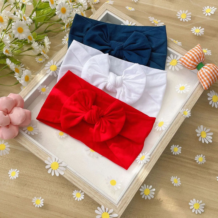 Navy, white, and red bow headbands arranged in a frame
