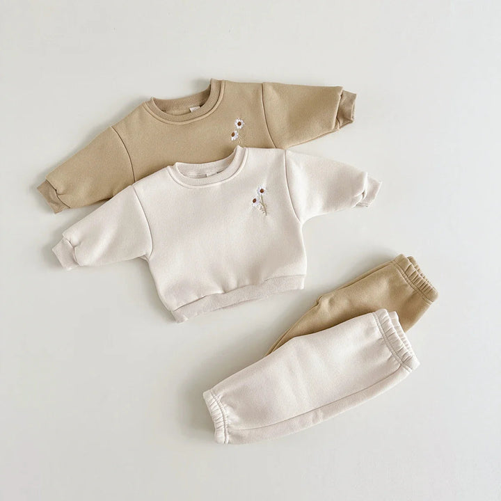 Beige and khaki floral sweaters with matching pants arranged separately