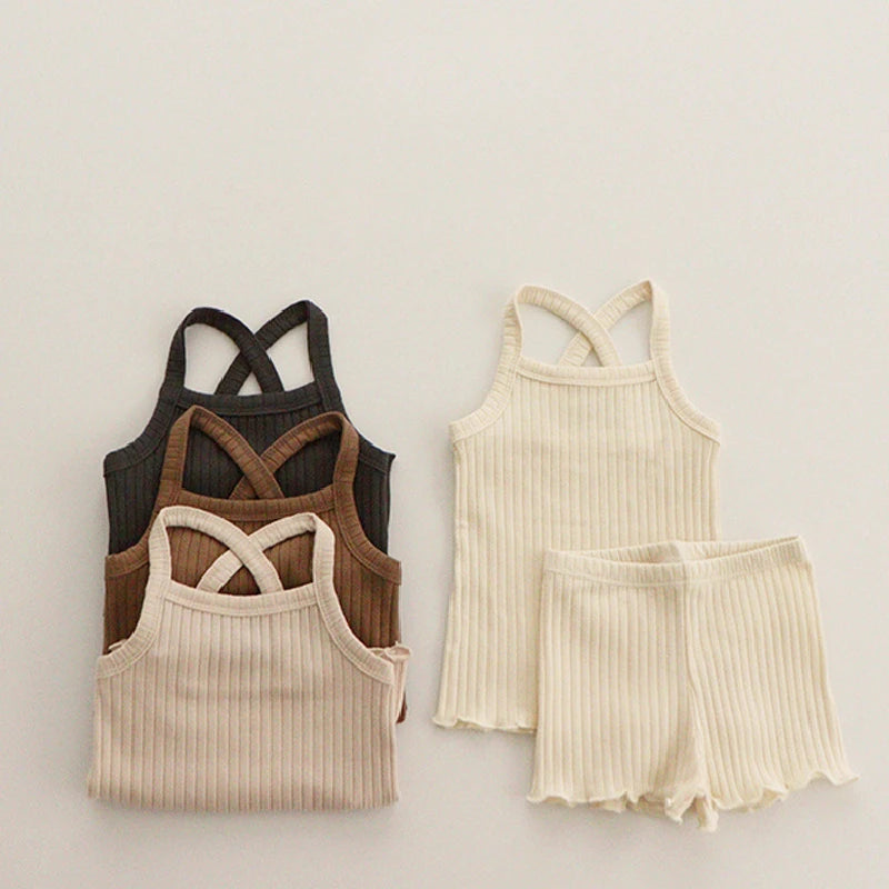 Ribbed pajama tops in black, brown, and beige beside a light beige tank-and-shorts set